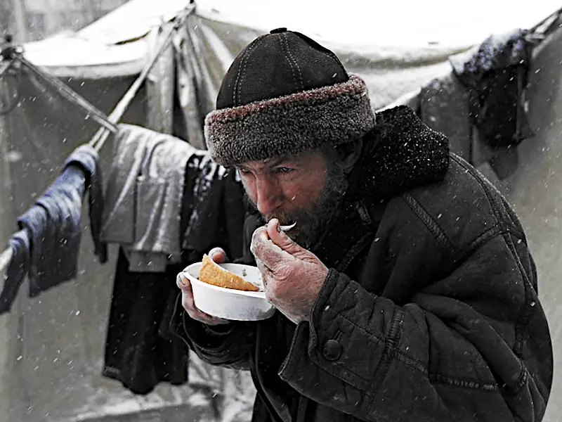 Бездомный ест на улице